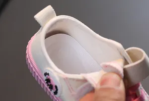 Gros plan sur la doublure textile douce des chaussures en toile roses et blanches
