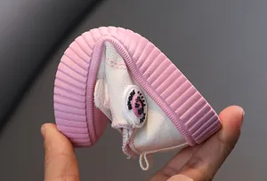 Vue détaillée d'une chaussure en toile rose souple pour enfant pliée à la main