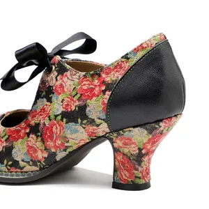 Detail view of vintage floral print high heel shoe with black ribbon bow and leather heel.