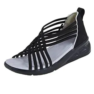 Vista lateral de sandalias negras para mujer con correas cruzadas y suela de cuña