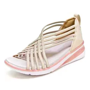 Vista detallada de sandalias de cuña para mujer con correas cruzadas en rosa.
