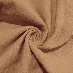 Dettaglio della trama del tessuto traspirante in cotone e lino marrone per pantaloni
