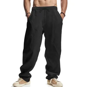 Detailed view of men's loose fit black linen pants with an elastic drawstring waist.