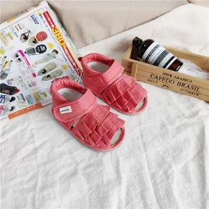 Nahaufnahme von rosafarbenen Mädchen-Sandalen mit Rüschen, weicher Sohle und CONOCO-Logo