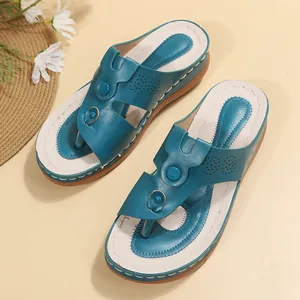 Detailed view of teal blue clip-toe wedge sandals with a perforated leather design