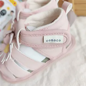 Nahaufnahme der rosa Prinzessinnen-Sandale für Kleinkinder mit conoco-Markenetikett