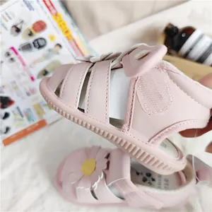 Nahaufnahme von rosa Baby-Prinzessinnen-Sandalen mit Gänseblümchen-Design und weicher Sohle