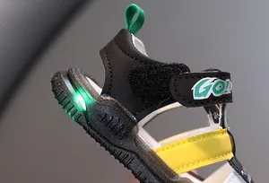 Detailaufnahme von Kinder-Leuchtsandalen mit einem leuchtend grünen LED-Licht an der Ferse