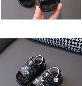 Close-up detail of black toddler sandals featuring cute panda patterns and velcro straps.