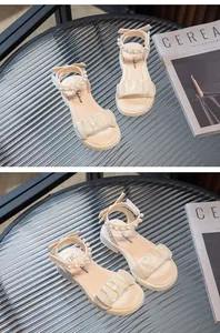 Gros plan de sandales crème pour filles avec brides en perles et détails de volants