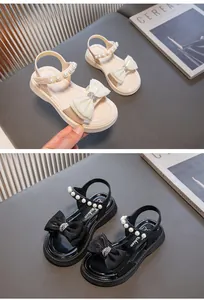 Detailansicht von Mädchensandalen mit Schleife, Perlen und Strass in Beige und Schwarz