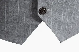 Macro detail of a grey pinstripe men's suit vest showing fabric texture and button closure.