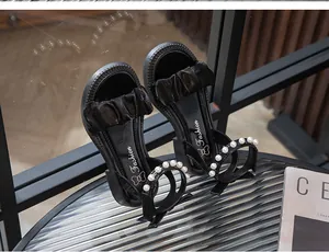 Sandales noires élégantes pour filles avec des brides à volants et des perles de nacre
