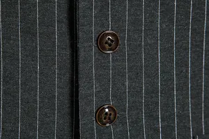 Close-up detail of a vintage men's pinstripe suit waistcoat with textured brown buttons