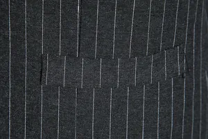 Detailed macro view of a men's pinstripe suit vest pocket showing fine fabric texture