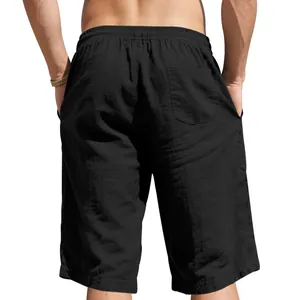 Back view of men's loose black linen shorts featuring an elastic waist and back pocket.