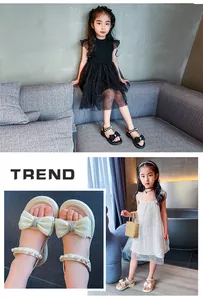 Nahaufnahme von beigen Sandalen für Mädchen mit schöner Schleife und edlen Perlenriemen