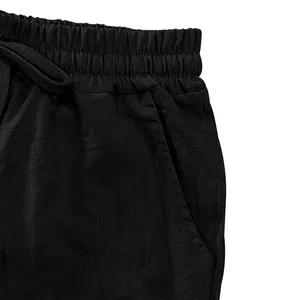 Close-up detail of black linen casual shorts with elastic waistband and drawstring