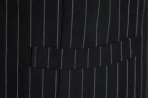 Macro view of men's black pinstripe suit vest showing premium fabric texture and pocket flap