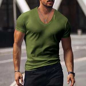 Muscular man wearing olive green V-neck short sleeve T-shirt in urban city street