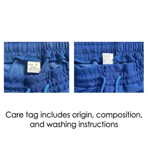 Close-up of washing care label on blue waffle fabric pants showing 100% polyester