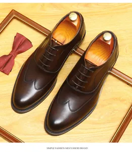 Detailansicht brauner Leder-Oxfordschuhe mit Wingtip-Stich auf Holzhintergrund