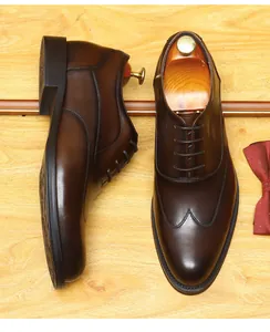 Detailansicht dunkelbrauner Oxford-Schuhe aus Leder mit Schuhspannern auf Holzfläche