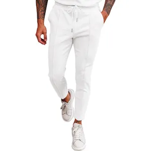 Detail view of men's white waffle knit drawstring pants with a modern tapered fit