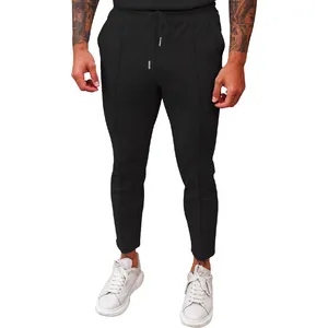 Detail of men's black waffle knit trousers with drawstring waist and straight fit