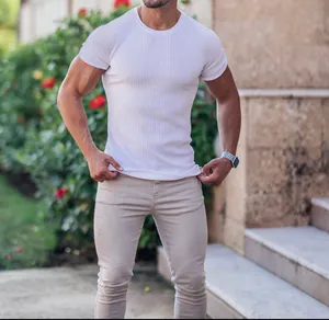 Close-up of men's white ribbed muscle fit T-shirt with short sleeves outdoors