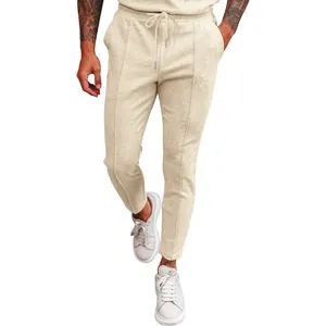 Detailed shot of men's beige waffle knit jogger pants with adjustable drawstring waist.