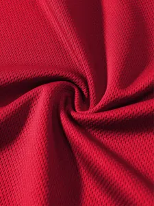 Vista macro del tessuto a rete rosso traspirante per canotte sportive professionali
