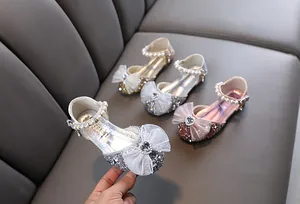 Detailansicht glitzernder Prinzessinnenschuhe für Mädchen mit Schleife und Perlenband