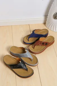 Varietà di sandali con zeppa da donna in quattro colori su pavimento in legno
