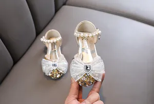 Detailansicht der gold glitzernden Prinzessinnenschuhe mit Schleife und Herzstein