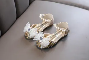 Detailansicht goldene Prinzessinnenschuhe für Mädchen mit Spitzenschleife und Perlen