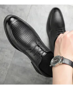 Draufsicht auf schwarze, perforierte Herren-Business-Schuhe mit Schnürung im Detail