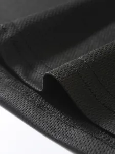 Primo piano di tessuto mesh traspirante nero con dettagli di cuciture sportive di qualità.