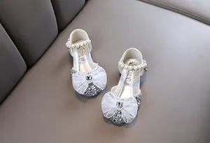 Detailansicht silberner Prinzessinnenschuhe für Mädchen mit Spitzenschleife und Perlen