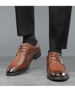 Detailansicht brauner Herren-Business-Lederschuhe mit Lochmuster zu schwarzer Hose