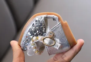 Nahaufnahme von silbernen Pailletten-Prinzessin-Sandalen für Mädchen mit Perlenband