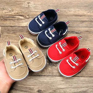 Gedetailleerde weergave van canvas babyloopschoenen in marineblauw, kaki en rood