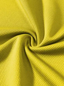 Dettaglio macro di alta qualità del tessuto a rete giallo traspirante per canotte sportive.