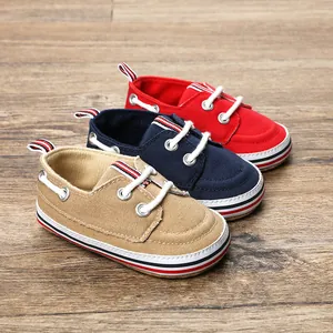 Detail van zachte canvas baby loopschoentjes in rood, marineblauw en khaki.