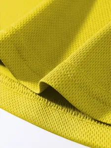 Primo piano del tessuto a rete traspirante giallo della canotta sportiva uomo fitness