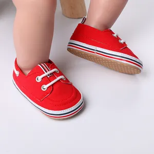 Detailopname van rode baby loopschoentjes met antislipzolen en witte veters