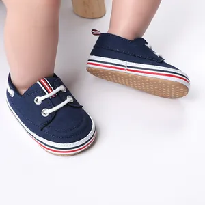 Gedetailleerd aanzicht van donkerblauwe canvas baby loopschoentjes aan kleine voetjes