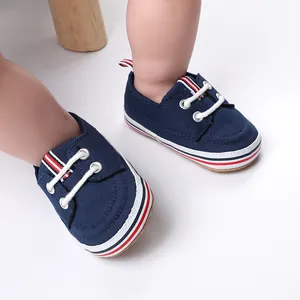 Detailopname van marineblauwe canvas babyloopschoenen voor peuters met rood-witte strepen