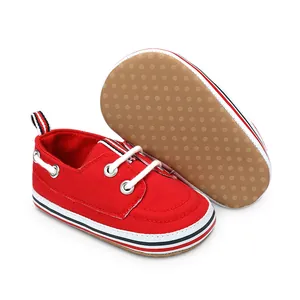 Detail van rode canvas baby loopschoentjes met antislip rubberen zolen voor stabiliteit