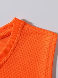 Primo piano del tessuto a rete arancione traspirante di una canotta sportiva da uomo.